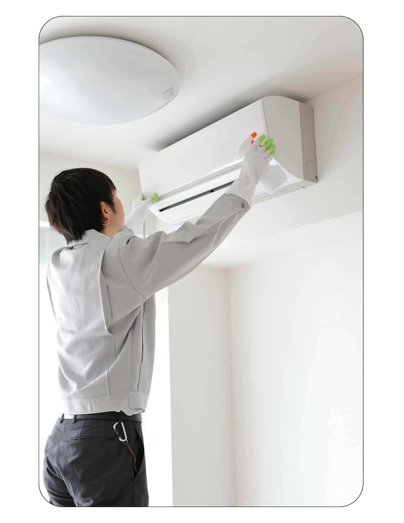 Un réparateur fait le nettoyage de la thermopompe murale.